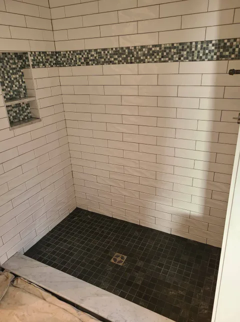 Tile walk-in shower with a mosaic accent border and slate floor, Upper Valley NH