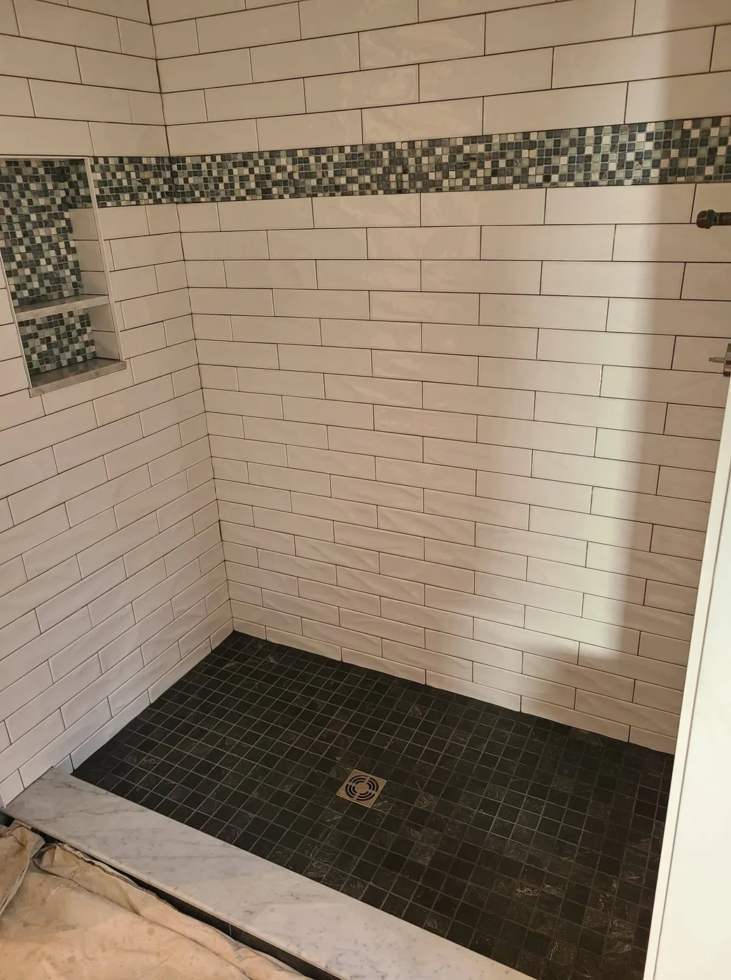 Tile walk-in shower with a mosaic accent border and slate floor, Upper Valley NH