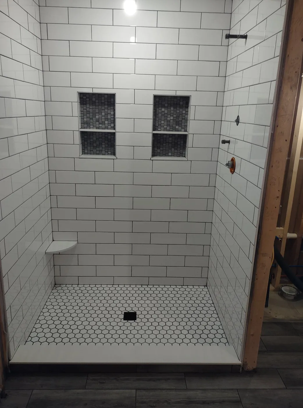 Walk-in subway-tile shower with built-in niches and a hex-tile floor, Upper Valley NH