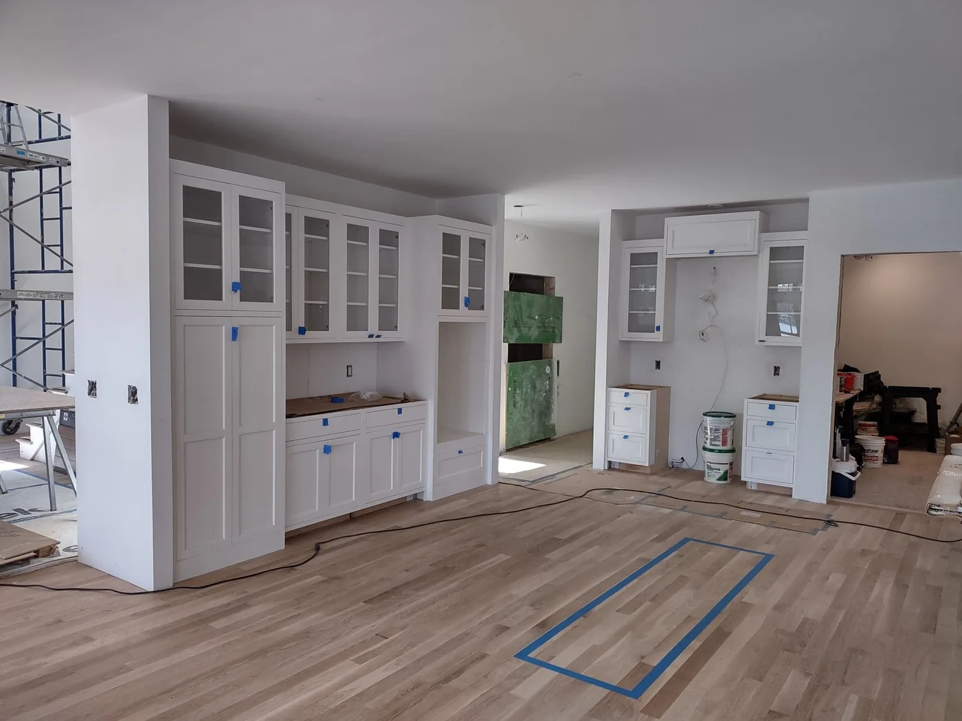 White custom kitchen with glass-front cabinetry and hardwood floors, Upper Valley NH