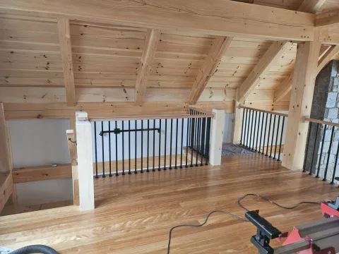 Timber-frame loft with a custom wood railing and pine ceiling, Upper Valley NH
